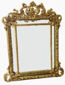19th century style giltwood carved mirror in rococo foliate frame with cupid surmount,