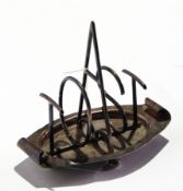 A silver stylistic four-division toast rack, the dividers spelling "TOAST", on bun feet,