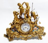 Late 19th century gilt metal mantel clock depicting putti playing instruments and dancing on rocky