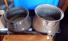 An Eastern copper cauldron with swing iron handle together with another,