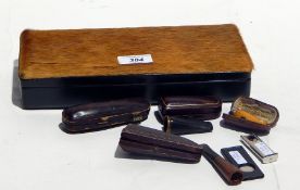 A quantity of amber cigarette holders and cigar cutters in a leather and deer hide box