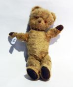 A gold plush teddy bear with stitched snout,