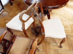 A pair of Victorian rosewood balloonback dining chairs with C-carved scrolled backs,