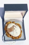 Gold-coloured metal carved shell cameo brooch, the shell carved with girl and dog seated,