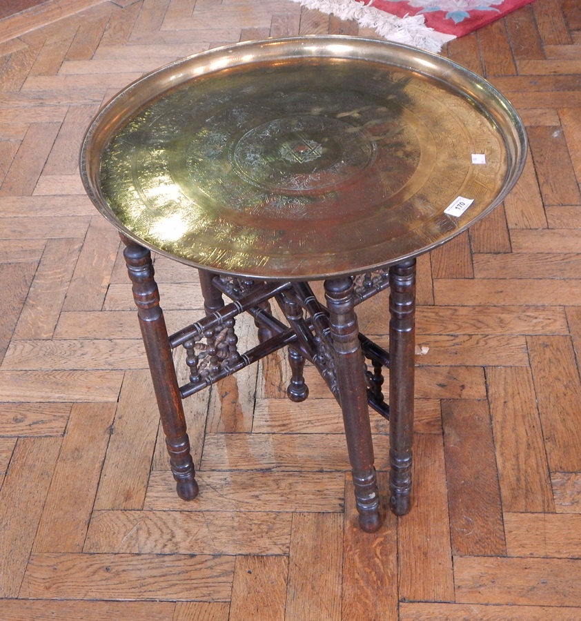 An Indian brass circular tray top table with folding stand,