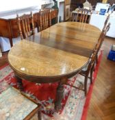 Reproduction carved oak extending dining table having curved ends,