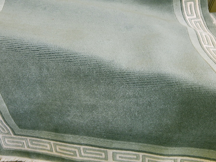 Green ground wool rug with greek key border,