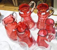 Six various cranberry and clear jugs (some af) and three various paperweights