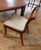 A set of four Regency style dining chairs with bar backs, upholstered drop-in seats,