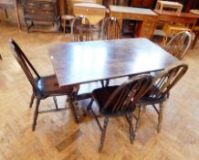 A reproduction oak rectangular top dining table on trestle supports with central stretcher,