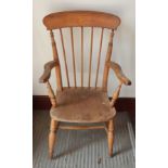 A Windsor hardwood armchair with stick back supports on tapering legs