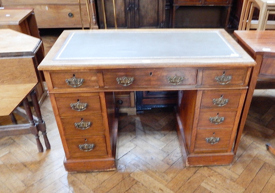 A late 19th century mahogany pedestal desk with inset writing surface, three frieze drawers,