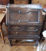 A reproduction stained oak bureau with fitted interior, with two long drawers,