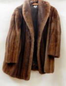 A three-quarter length mink jacket with shawl collar and bell sleeves  Live Bidding: If you would