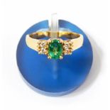 Emerald and diamond ring set central oval cut emerald flanked by two pairs of small diamonds  Live