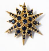 A gold and sapphire starburst brooch, six-pointed star with alternating points set numerous,
