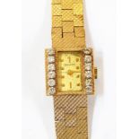 Lady's Bulova gold coloured metal and diamond set wristwatch having rectangular dial, set two rows