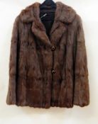 A vintage fur coat, possibly squirrel, trimmed with black and brass buttons  Live Bidding: If you