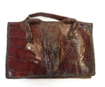 A vintage crocodile handbag, with the face and feet of the crocodile incorporated.