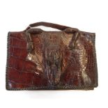 A vintage crocodile handbag, with the face and feet of the crocodile incorporated.