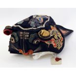 Chinese silk child's hat, embroidered with a cats face bearing a label with sealing wax stamp Live