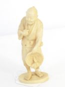 Japanese carved ivory figure of a man holding bird and basket with radish, on oval base, signed, 12.