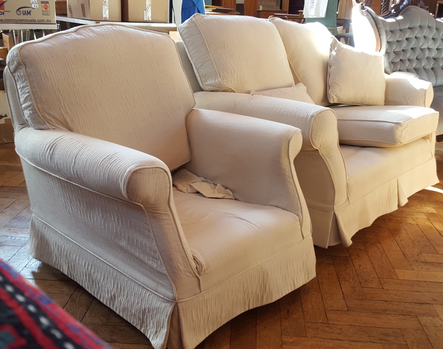 Two-seater sofa with loose cushions and matching armchair with beige upholstery