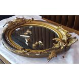 Oval gilt mirror with floral decoration to top and bottom