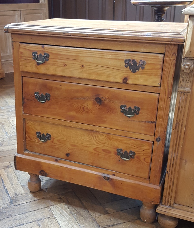 Pine chest of three long graduated drawers, on bun feet,