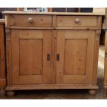 Old pine side cupboard with moulded top and two frieze drawers, cupboard below, on bun feet,