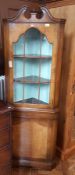 Yew and glass fronted corner cabinet with three shelves and one drawer underneath,