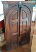 18th century oak corner cupboard, the arched panel doors enclosing shelves,