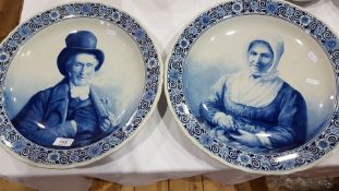 Pair Dutch delft pottery plaques painted with seated lady wearing bonnet,