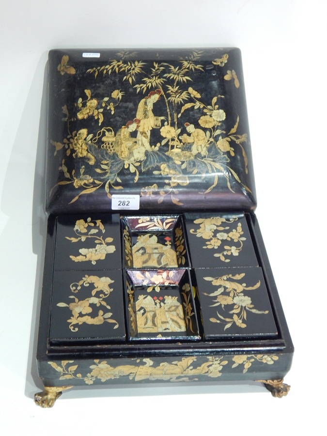 Chinese lacquer games box depicting figures taking tea in a garden,