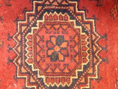 Persian style wool carpet, red ground with hexagonal guls, lozenge border,