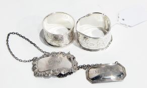 20th century silver napkin ring with floral engraving and bead border with another,