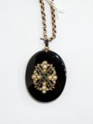 Victorian black onyx and pearl locket, the oval black onyx ground with locket to reverse,
