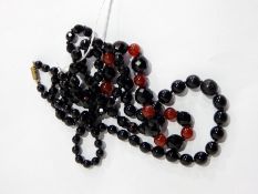 Jet and cornelian graduated bead necklace and another black bead necklace,