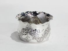 Edwardian small silver dish of tapered form, with wavy rim and repousse floral swag decoration,