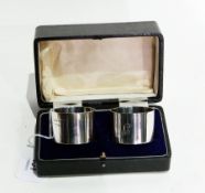 Pair of cased napkin rings of plain form with engraved initials,