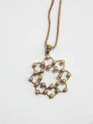 15ct gold and seedpearl snowflake-pattern pierced pendant on fine herringbone chain