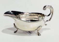 Edwardian silver sauceboat with gadrooned borders and three shell to paw feet, London 1904,