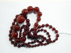 Long string of graduated red amber beads,