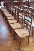 Harlequin set of seven oak ladderback dining chairs with rush seats,