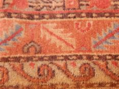 Wool rug, the pink ground with hooked medallions and foliate border,