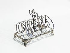 Victorian silver six-division toast rack with carrying handle and raised on cast foliate feet,
