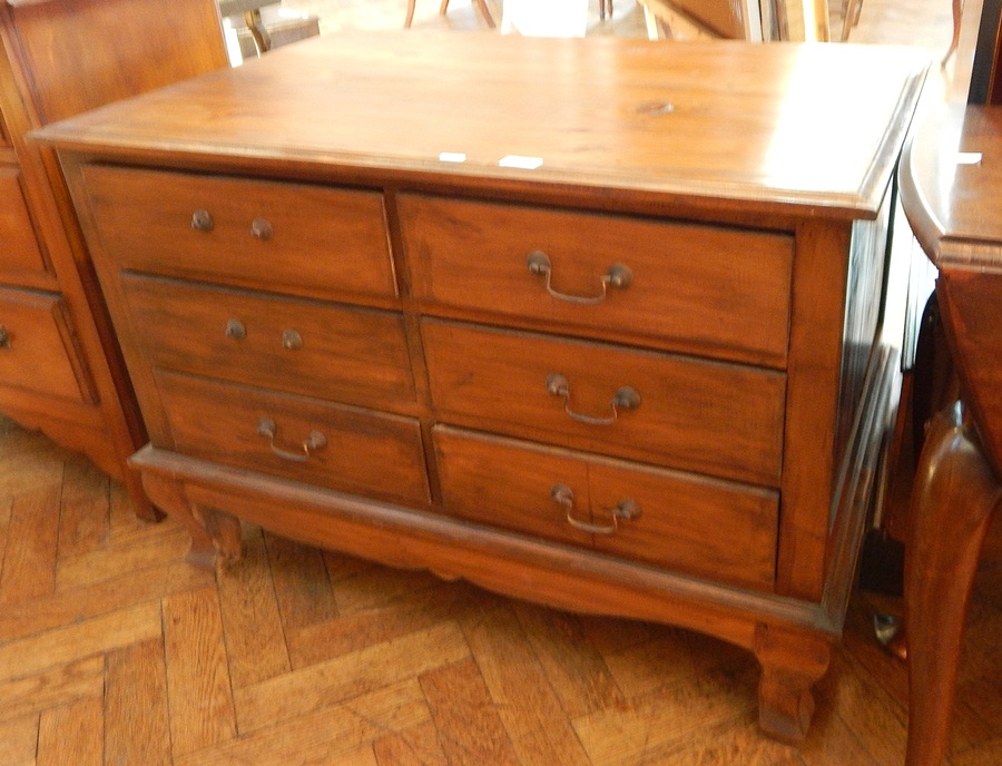 An Eastern hardwood chest of six short drawers raised on short square cabriole legs,