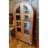 An Eastern hardwood glazed bookcase with domed top, pair of doors enclosing shelves,