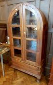 An Eastern hardwood glazed bookcase with domed top, pair of doors enclosing shelves,