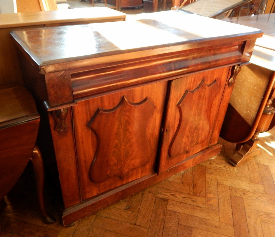 A Victorian mahogany two-door chiffonier having a cushion moulded drawer over two shield panelled